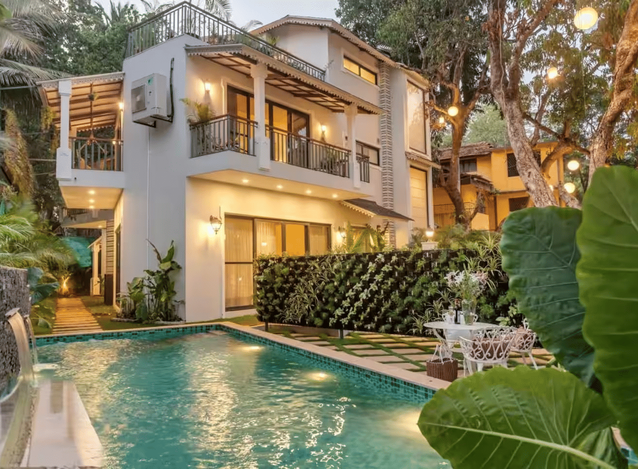 Exterior view of the villa with a pool surrounded by lush plants at Lime Tree Villa with Private Pool | Luxury Stay in Goa.